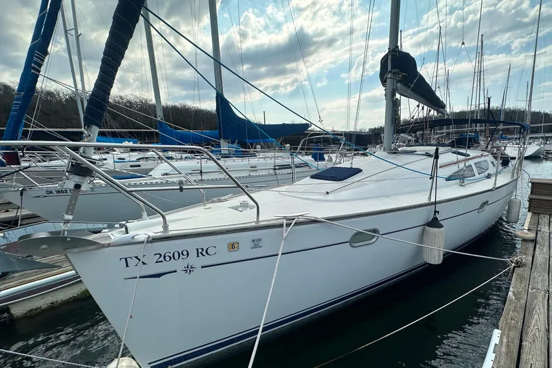 Slide: The Image of 2004 Jeanneau Sun Odyssey 35 sailboat docked at marina under cloudy sky. - 9