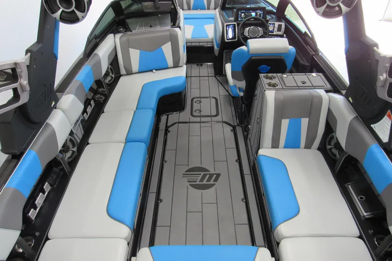 Slide: The Image of 2021 Malibu Wakesetter 24 MXZ interior with blue and gray seating, modern dashboard. - 3