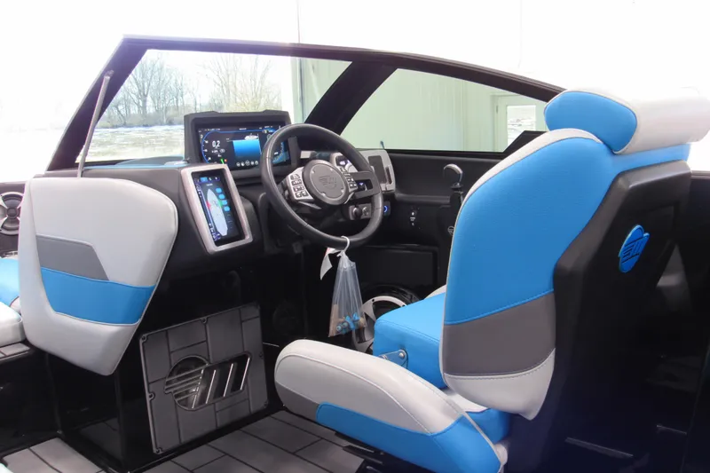 Slide: The Image of 2021 Malibu Wakesetter 24 MXZ interior with blue and white seating, modern dashboard. - 7
