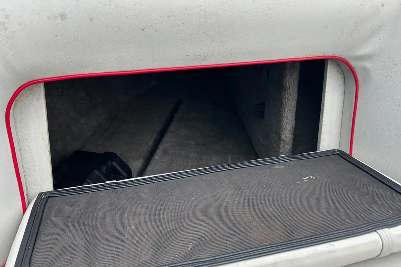 Slide: The Image of 1988 Supra Comp boat storage compartment with red trim and black interior. - 10