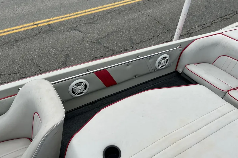 Slide: The Image of 1988 Supra Comp boat interior with white and red upholstery, speakers, and road background. - 11