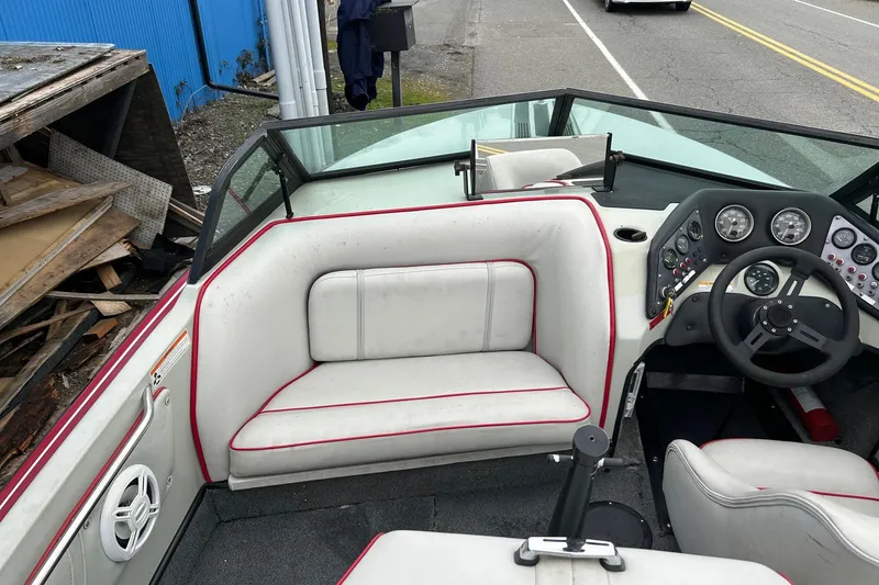 Slide: The Image of 1988 Supra Comp boat interior with white and red seating, dashboard, and steering wheel. - 6
