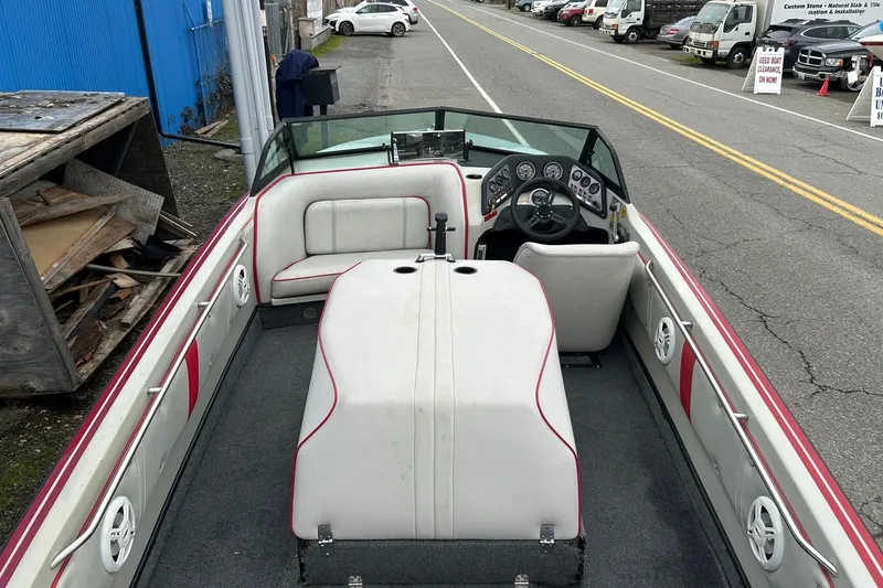Slide: The Image of 1988 Supra Comp boat interior with white and red seating, steering wheel, and dashboard. - 9