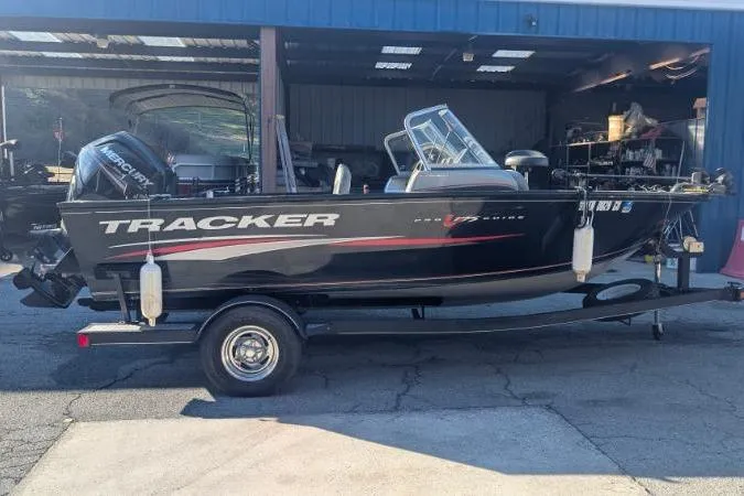 The Image of 2017 Tracker Pro Guide V-175 Combo boat on trailer, parked outside a garage. - 0