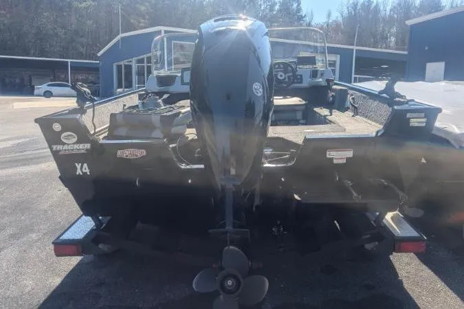 Slide: The Image of 2017 Tracker Pro Guide V-175 Combo boat, rear view with motor, parked outdoors. - 10