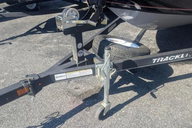 Slide: The Image of 2017 Tracker Pro Guide V-175 Combo trailer hitch and spare tire on asphalt. - 5