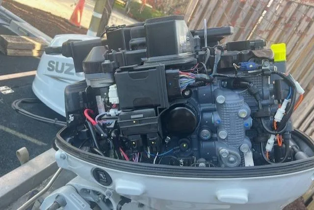 Slide: The Image of Open Suzuki outboard motor engine with visible wiring and components. - 7