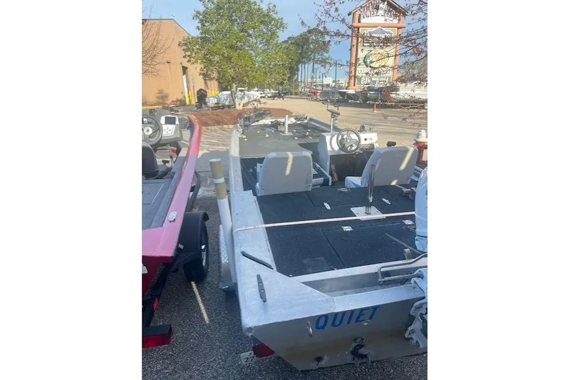 Slide: The Image of 1985 Grumman Outlaw boat parked outdoors, featuring dual seats and steering wheel. - 9