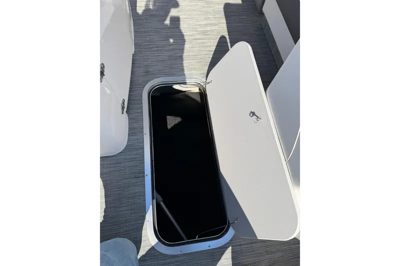Slide: The Image of Open storage compartment on 2021 Bennington QX 25 QXFBA boat deck. - 17