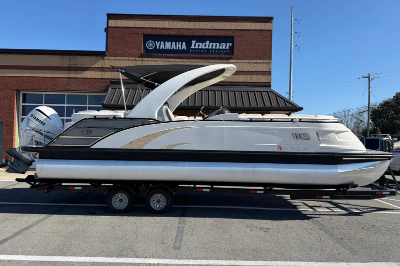Slide: The Image of 2021 Bennington QX 25 QXFBA pontoon boat on trailer outside Yamaha Indmar building. - 25
