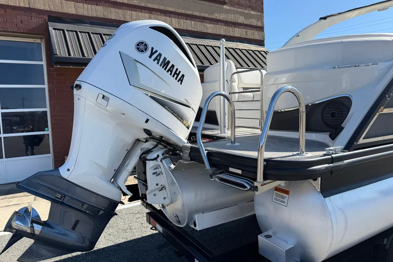 Slide: The Image of 2021 Bennington QX 25 QXFBA pontoon boat with Yamaha outboard motor, docked outdoors. - 6