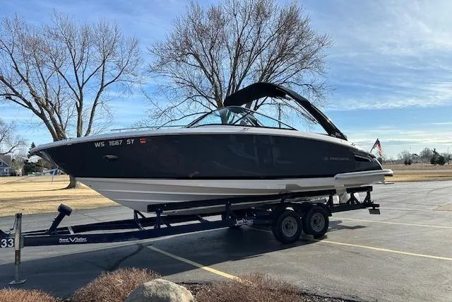 Slide: The Image of 2023 Regal 2800 Bowrider boat on trailer in parking lot, clear sky background. - 3