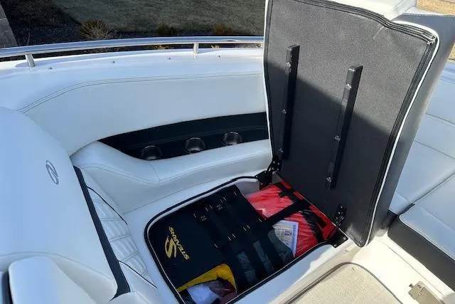 Slide: The Image of 2023 Regal 2800 Bowrider boat interior with open storage compartment and white seating. - 31