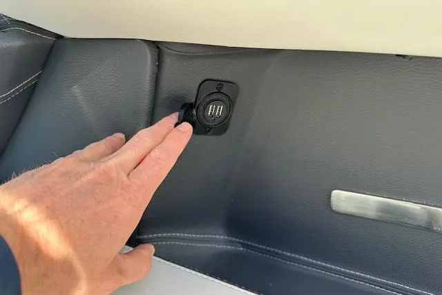 Slide: The Image of Hand touching USB port on 2023 Regal 2800 Bowrider boat interior. - 37