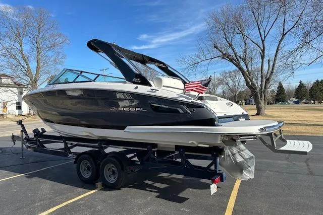 Slide: The Image of 2023 Regal 2800 Bowrider boat on trailer, parked outdoors with clear sky. - 4