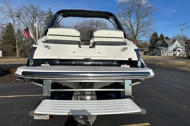 Slide: The Image of 2023 Regal 2800 Bowrider boat with extended swim platform, parked outdoors. - 7