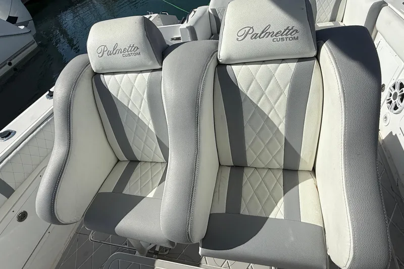Slide: The Image of Two cushioned seats on a 2001 Palmetto Custom 36 boat, featuring gray and white upholstery. - 16