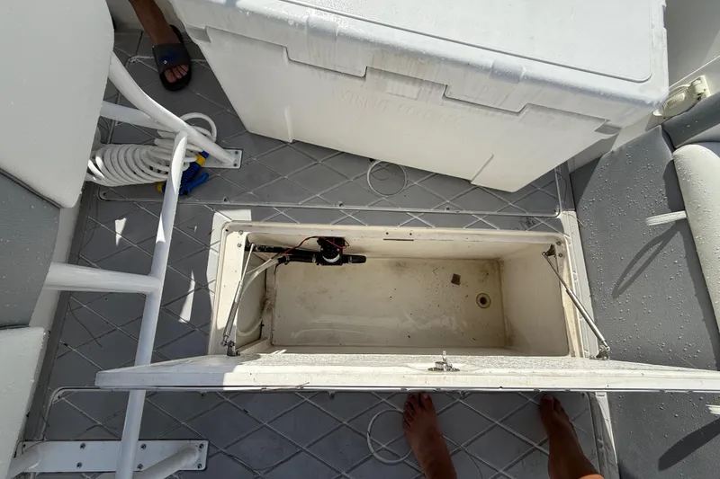 Slide: The Image of Open storage compartment on 2001 Palmetto Custom 36 boat deck, with cooler and hose nearby. - 23