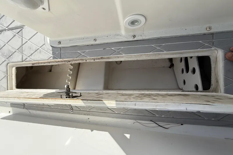 Slide: The Image of Storage compartment on a 2001 Palmetto Custom 36 boat, featuring a hatch and latch mechanism. - 24