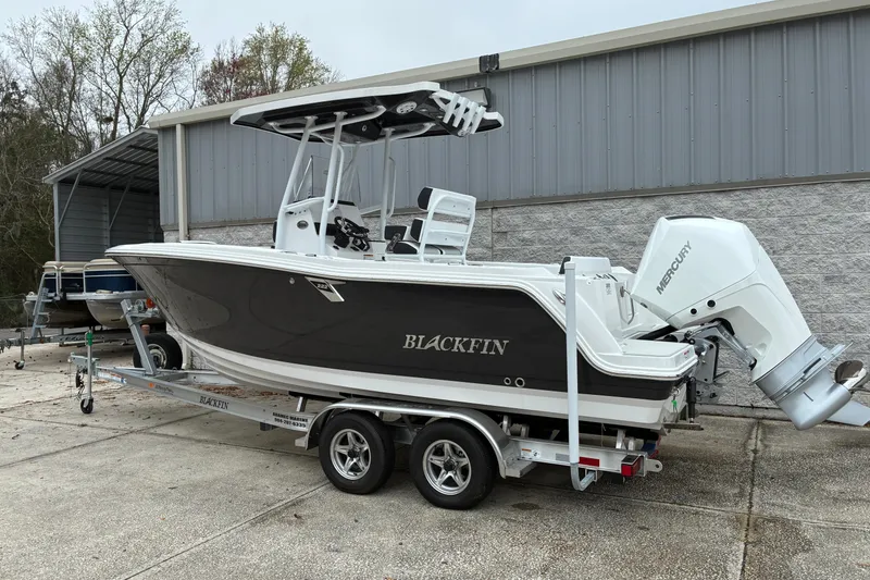Slide: The Image of 2026 Blackfin 222 CC boat on trailer, parked outside a metal building. - 3
