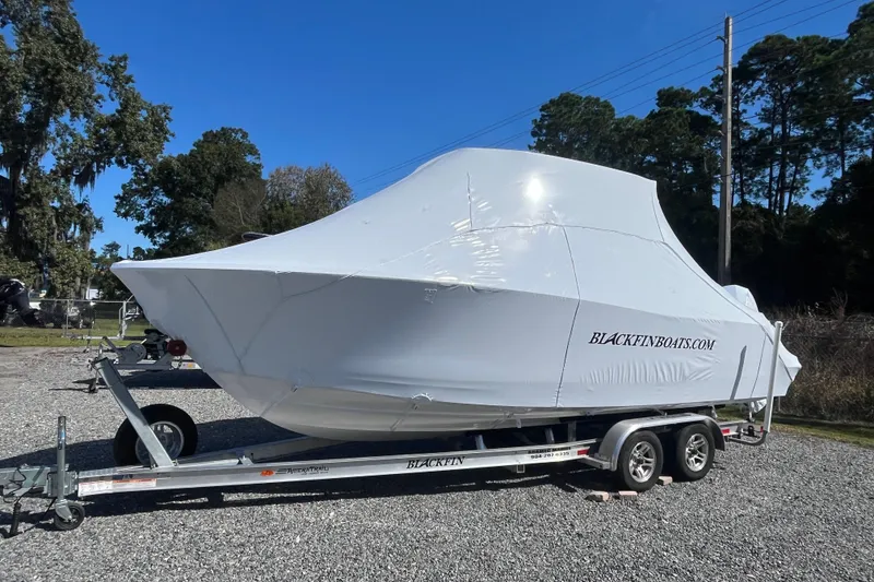 Slide: The Image of 2026 Blackfin 252 CC boat covered on trailer, parked outdoors. - 4