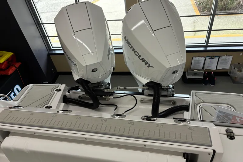 Slide: The Image of 2026 Blackfin 252 CC boat with dual Mercury outboard engines in showroom. - 9