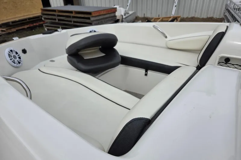 Slide: The Image of 2020 Stingray 182 SC boat interior with white and black seating, speaker, and storage. - 4