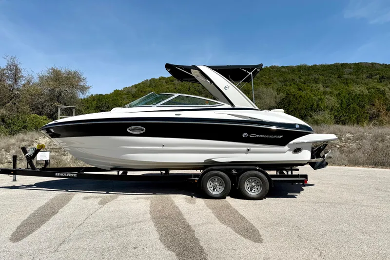 Slide: The Image of 2008 Crownline 260 LS boat on trailer, parked outdoors under clear blue sky. - 10