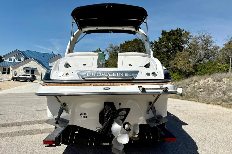 Slide: The Image of 2008 Crownline 260 LS boat parked on a sunny residential street. - 12