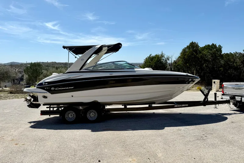 Slide: The Image of 2008 Crownline 260 LS boat on trailer, parked outdoors under clear blue sky. - 13