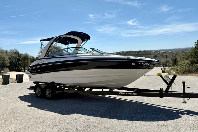 Slide: The Image of 2008 Crownline 260 LS boat on trailer, parked outdoors under clear sky. - 14