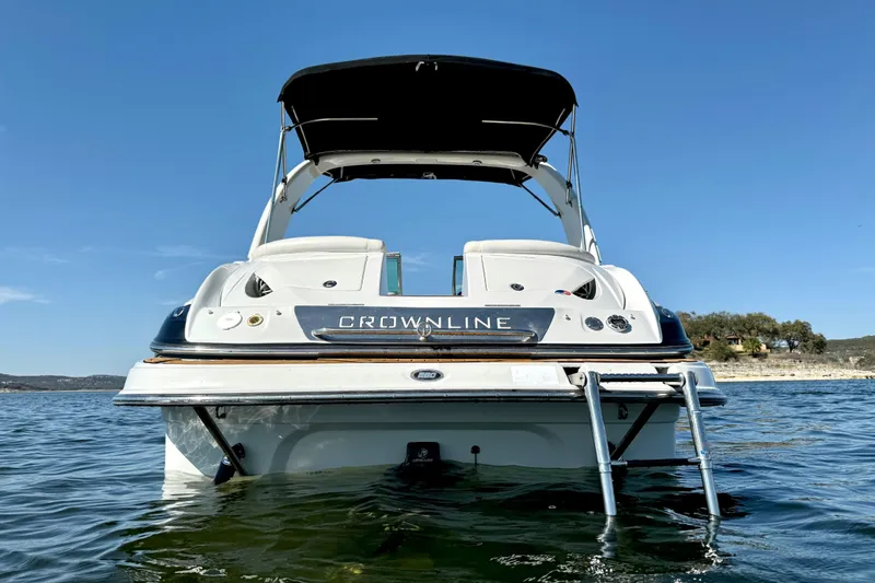 Slide: The Image of 2008 Crownline 260 LS boat on water, rear view with ladder and canopy. - 5