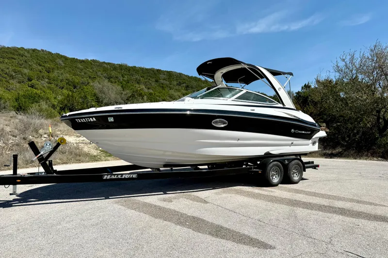Slide: The Image of 2008 Crownline 260 LS boat on trailer, parked outdoors with scenic background. - 9