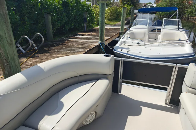 Slide: The Image of 2020 Cypress Cay Seabreeze 232 pontoon boat docked beside a wooden pier. - 20