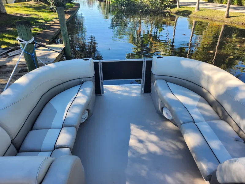 Slide: The Image of 2020 Cypress Cay Seabreeze 232 pontoon boat docked by palm trees. - 7