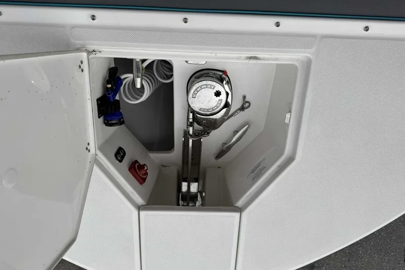 Slide: The Image of 2026 Regal 38 Surf boat anchor compartment with winch and coiled rope. - 24