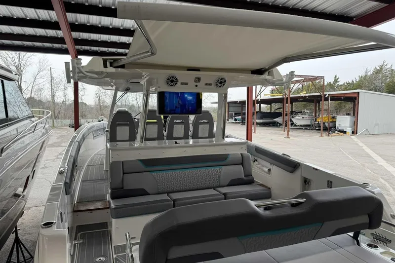 Slide: The Image of 2026 Regal 38 Surf boat interior with seating and entertainment system under a canopy. - 25