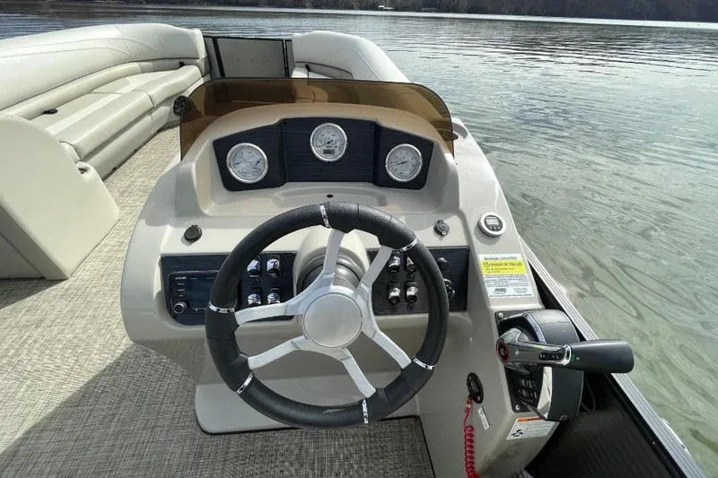 Slide: The Image of Steering console of 2023 Cypress Cay Seabreeze 252 pontoon boat on calm water. - 11