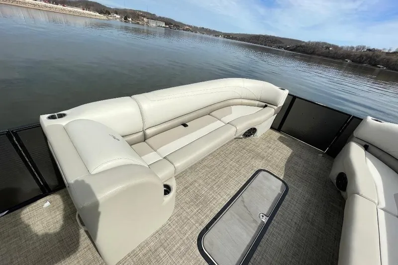 Slide: The Image of 2023 Cypress Cay Seabreeze 252 pontoon boat interior with beige seating on a calm lake. - 13