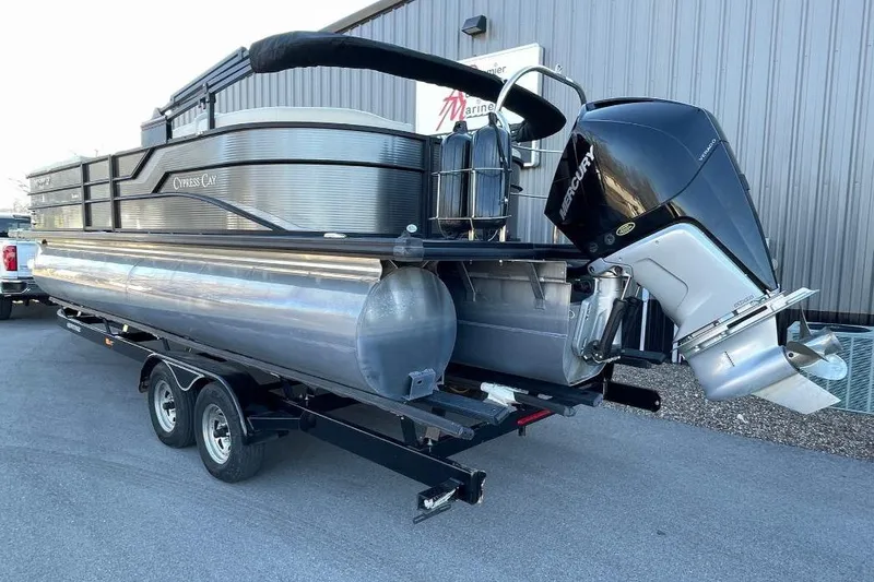 Slide: The Image of 2023 Cypress Cay Seabreeze 252 pontoon boat on trailer, featuring a Mercury outboard motor. - 3