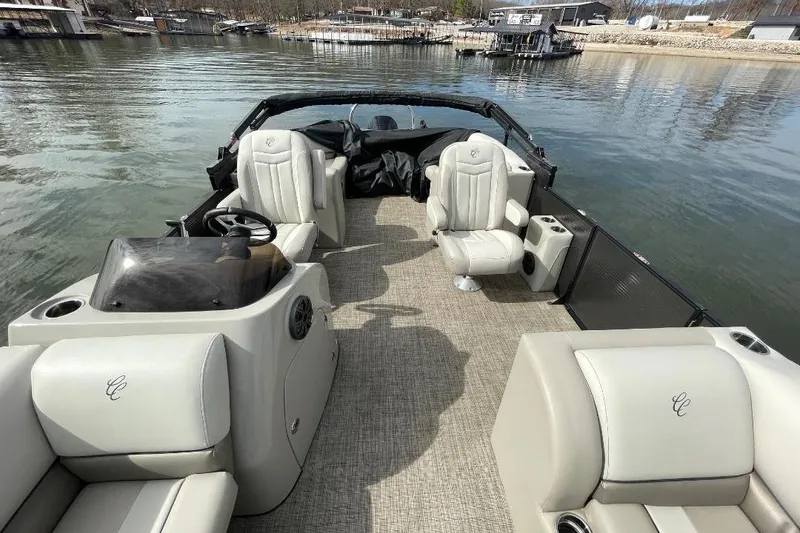 Slide: The Image of 2023 Cypress Cay Seabreeze 252 pontoon boat interior with plush seating on a calm lake. - 5
