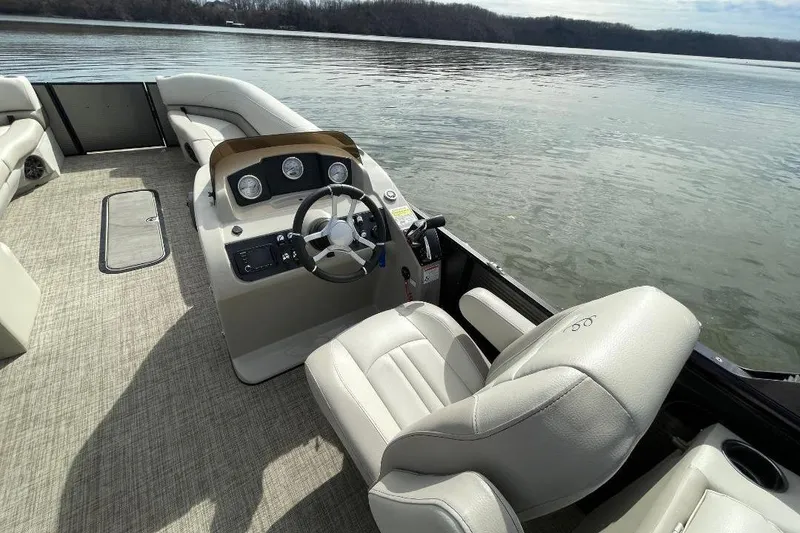 Slide: The Image of 2023 Cypress Cay Seabreeze 252 pontoon boat interior with steering wheel and seating. - 9