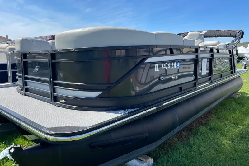 Slide: The Image of 2020 Starcraft SLS 3 pontoon boat with sleek black exterior on grassy area. - 5