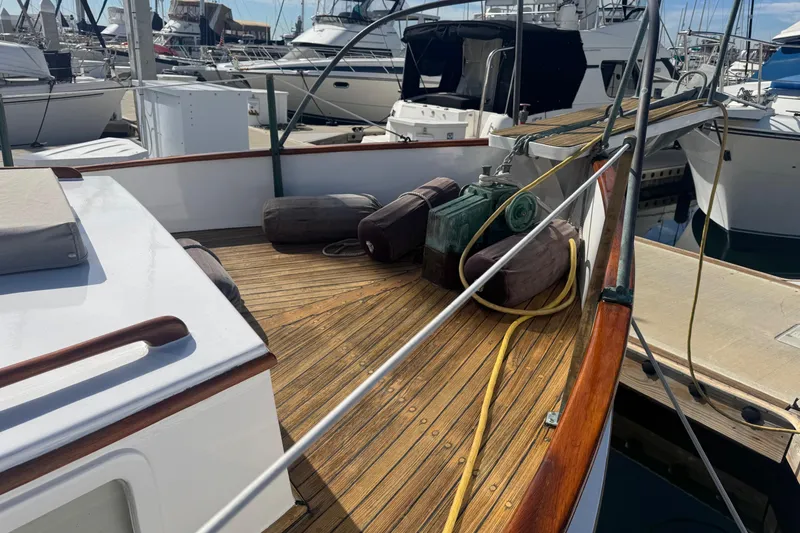 Slide: The Image of 1966 Grand Banks 32 Sedan boat deck with wooden finish, docked at marina. - 11