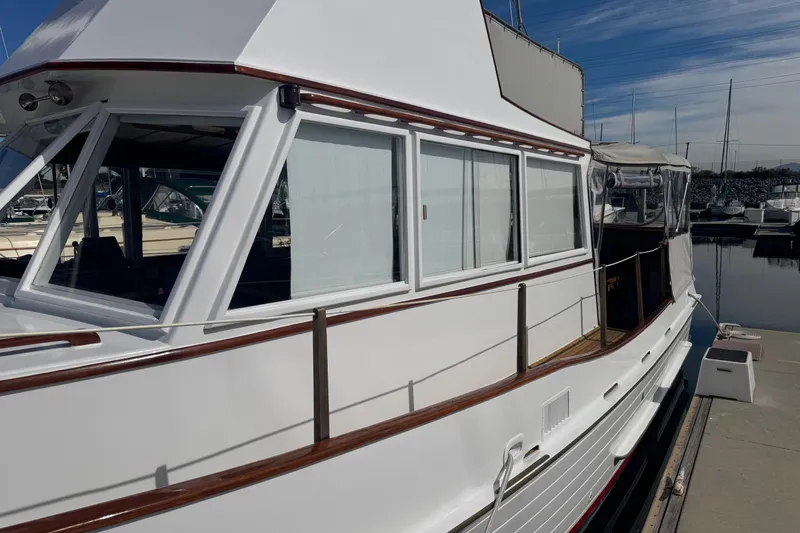 Slide: The Image of 1966 Grand Banks 32 Sedan boat docked at marina, showcasing classic design and wooden accents. - 12