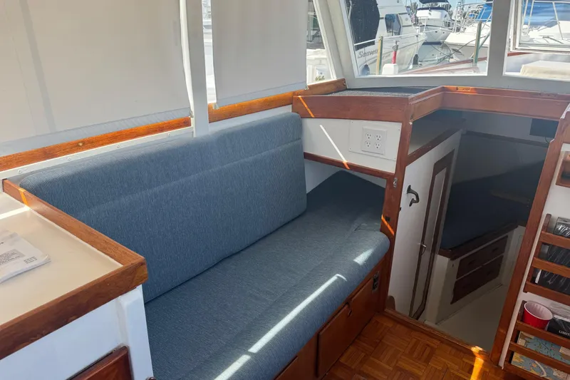 Slide: The Image of 1966 Grand Banks 32 Sedan interior with blue seating and wooden accents. - 18