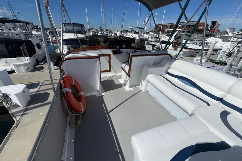 Slide: The Image of 1966 Grand Banks 32 Sedan boat interior with white seating and marina view. - 26