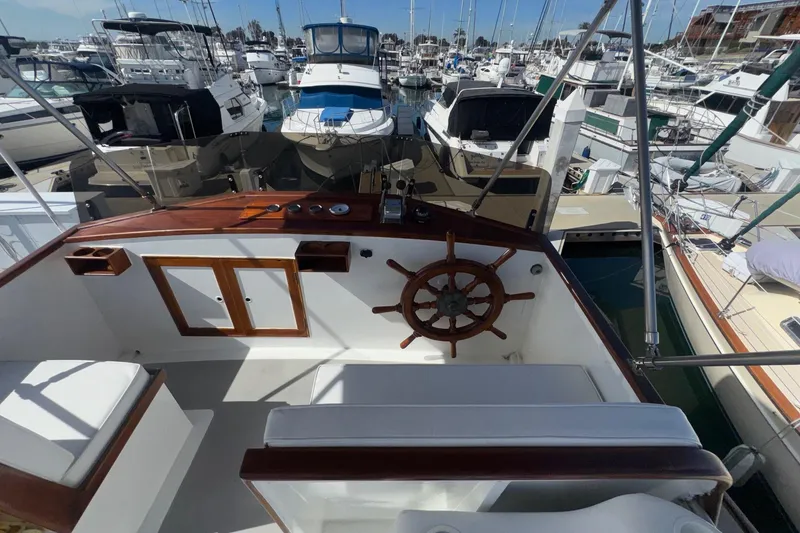 Slide: The Image of 1966 Grand Banks 32 Sedan boat helm with wooden wheel, docked in a marina. - 27