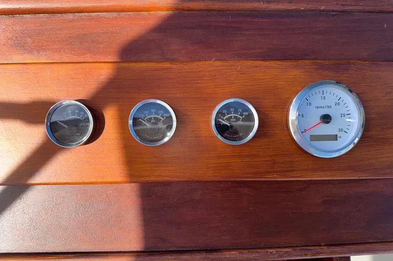 Slide: The Image of 1966 Grand Banks 32 Sedan dashboard with four gauges on wooden panel. - 29