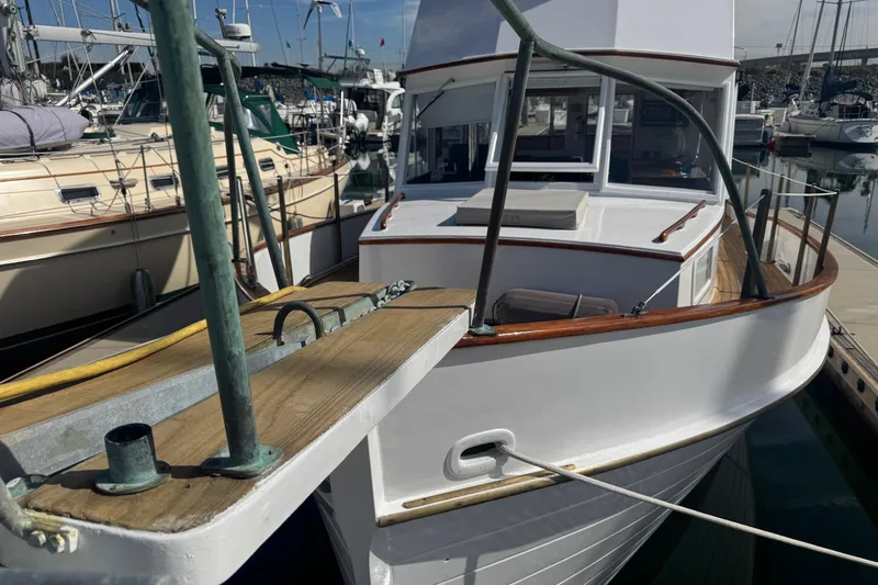 Slide: The Image of 1966 Grand Banks 32 Sedan boat docked in a marina, showcasing classic wooden design. - 3